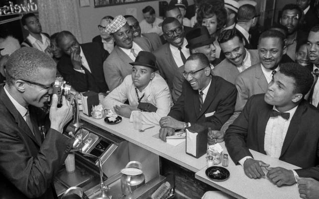 Malcolm X photographs Muhammad Ali at the victory party after Ali’s defeat of Sonny Liston, February 25, 1964. Photograph by Bob Gomel, Bob Gomel Photographic Archive. Briscoe Center for American History.